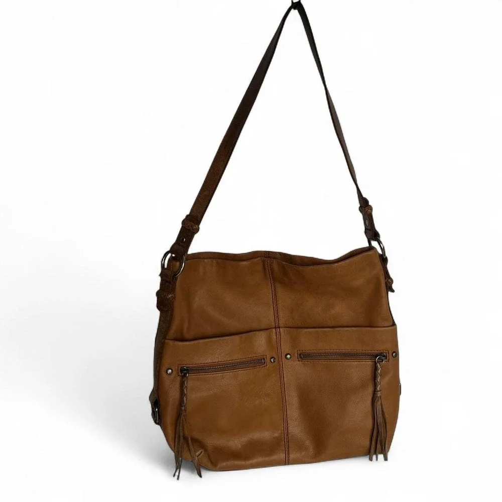 Tan leather shoulder bag with zipper closure, multiple pockets & braided tassel